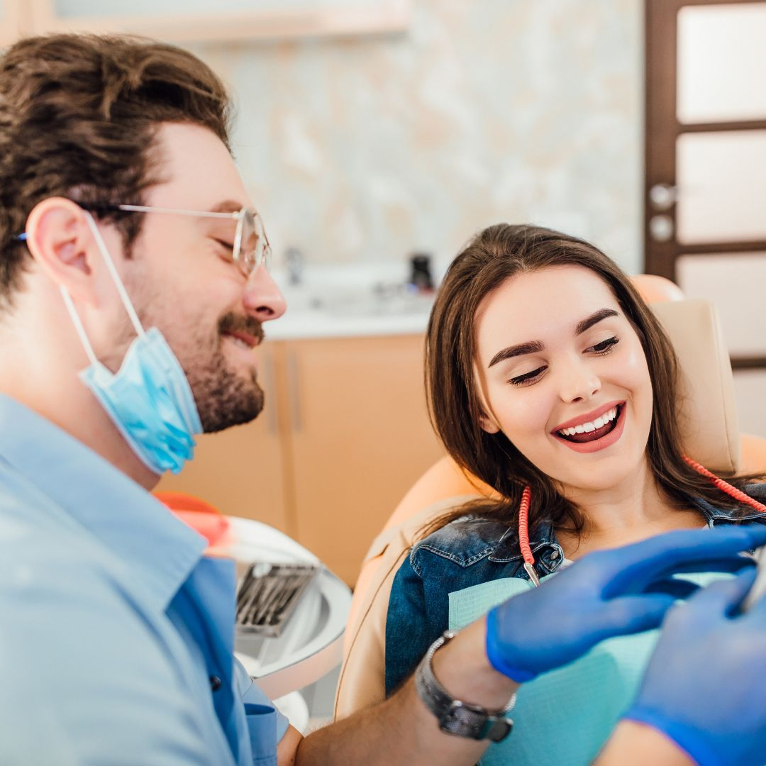 Dentista e paciente satisfeita durante consulta na clínica odontológica